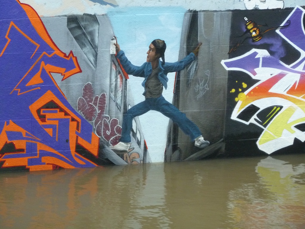 Hochwasser Dez23Jan24 Graffiti Sprayer zwischen Bahnen.jpg